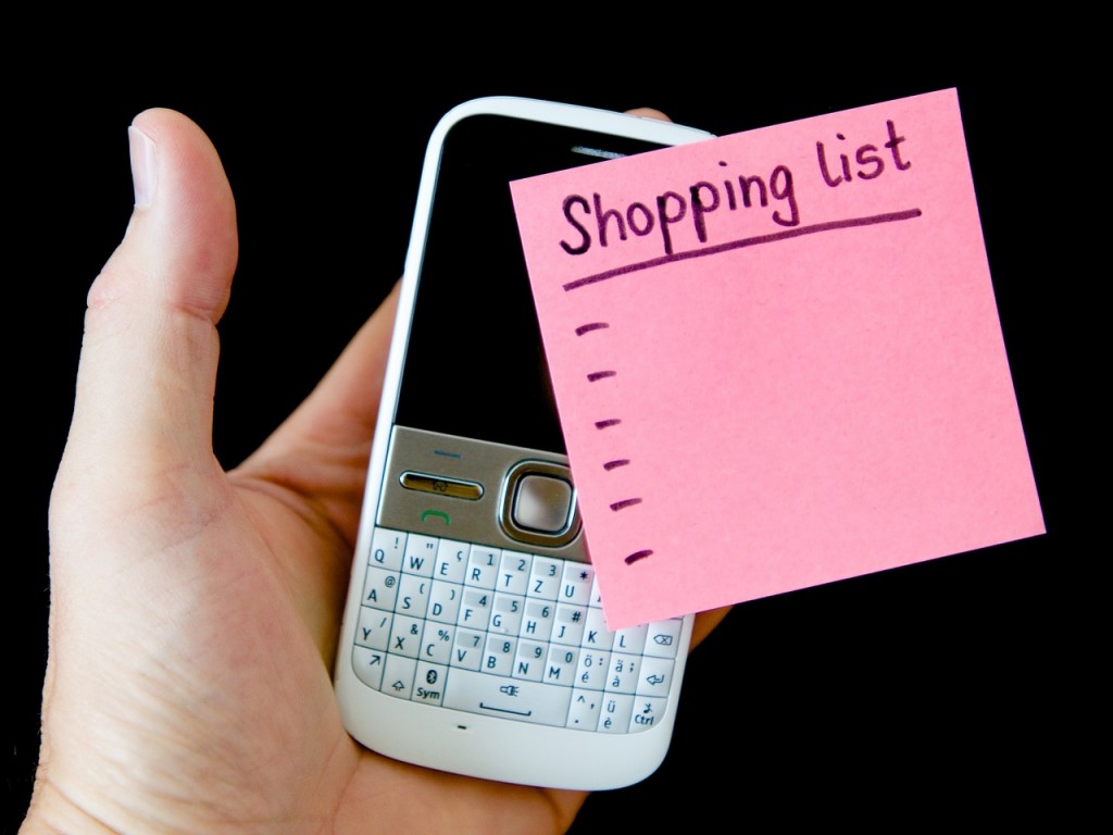 telefon vechi cu post-it roz cu lista de cumparaturi